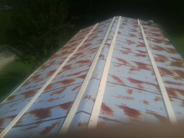 Rusted metal roof panels with new wood purlins before replacement — Storm Damage Roof Repair in New Stuyahok by Roofing Brothers