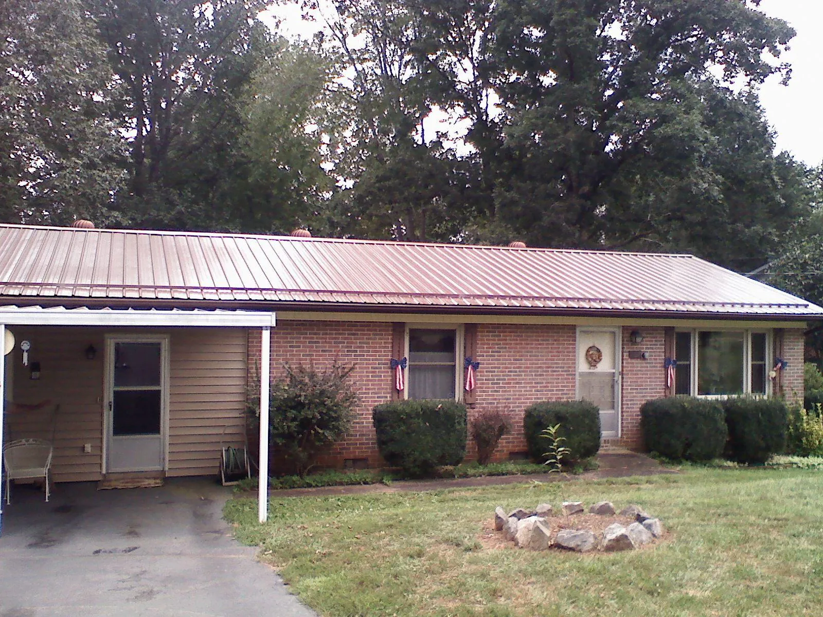 Bronze metal roof and carport on a brick ranch home — Roof Repair work by our crew in New Stuyahok