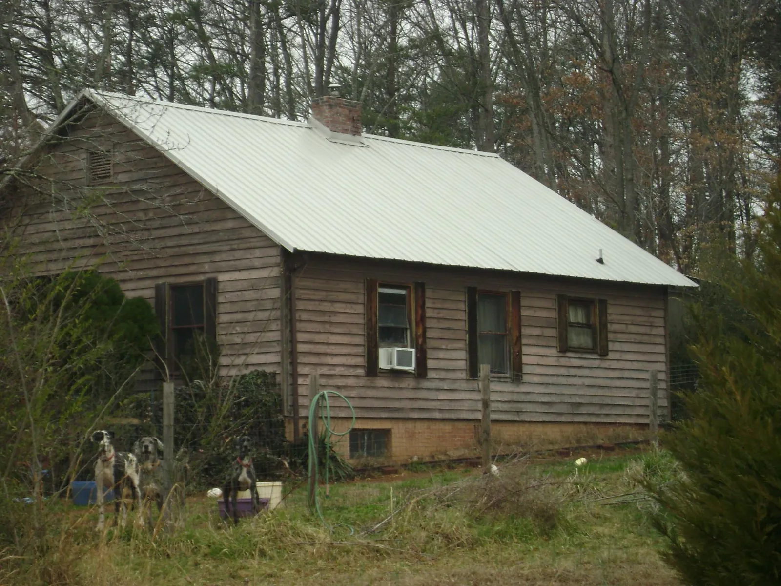 White metal roof on an old wood sided farmhouse, from a Asphalt Shingle Roof Repair job in New Stuyahok